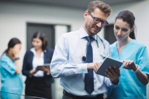 Equipe médica e administrativa analisando dados em ambientes hospitalares — colaboração para redução de glosas com gestão Medsol