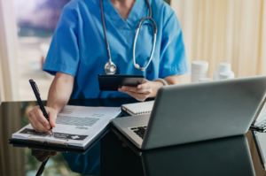Médico realizando gestão eficiente com tablet e laptop